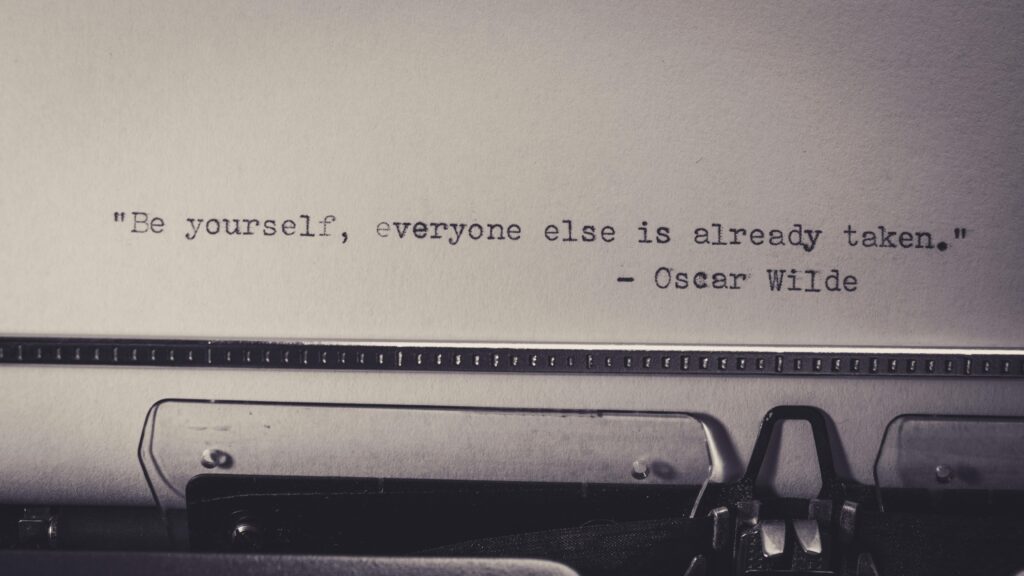 Vintage typewriter displaying Oscar Wilde's quote 'Be yourself, everyone else is already taken.'